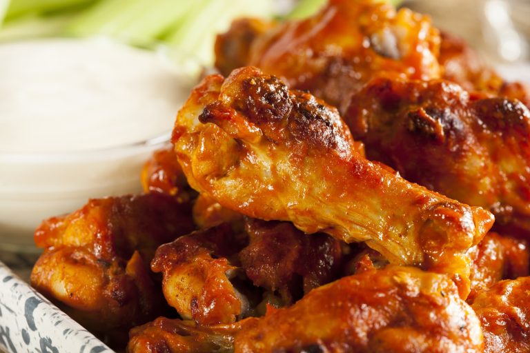 Ailes de poulet bufalo style restaurant servies avec une sauce au fromage bleu et des bâtonnets de céleri
