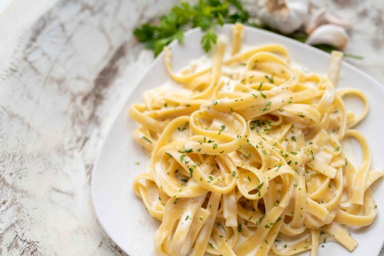 Pâtes fettuccine dans une sauce Alfredo servies sur une assiette blanche