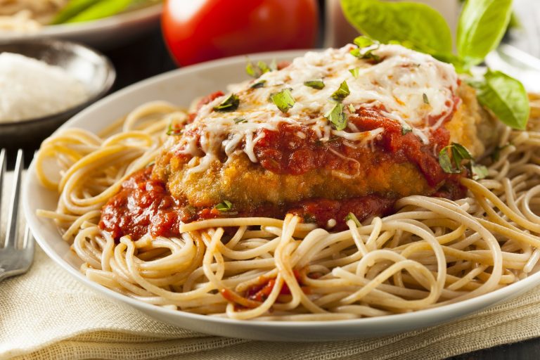 Poulet parmigiana maison gratiné et sauce tomate servi sur un lit de pâtes spaghetti
