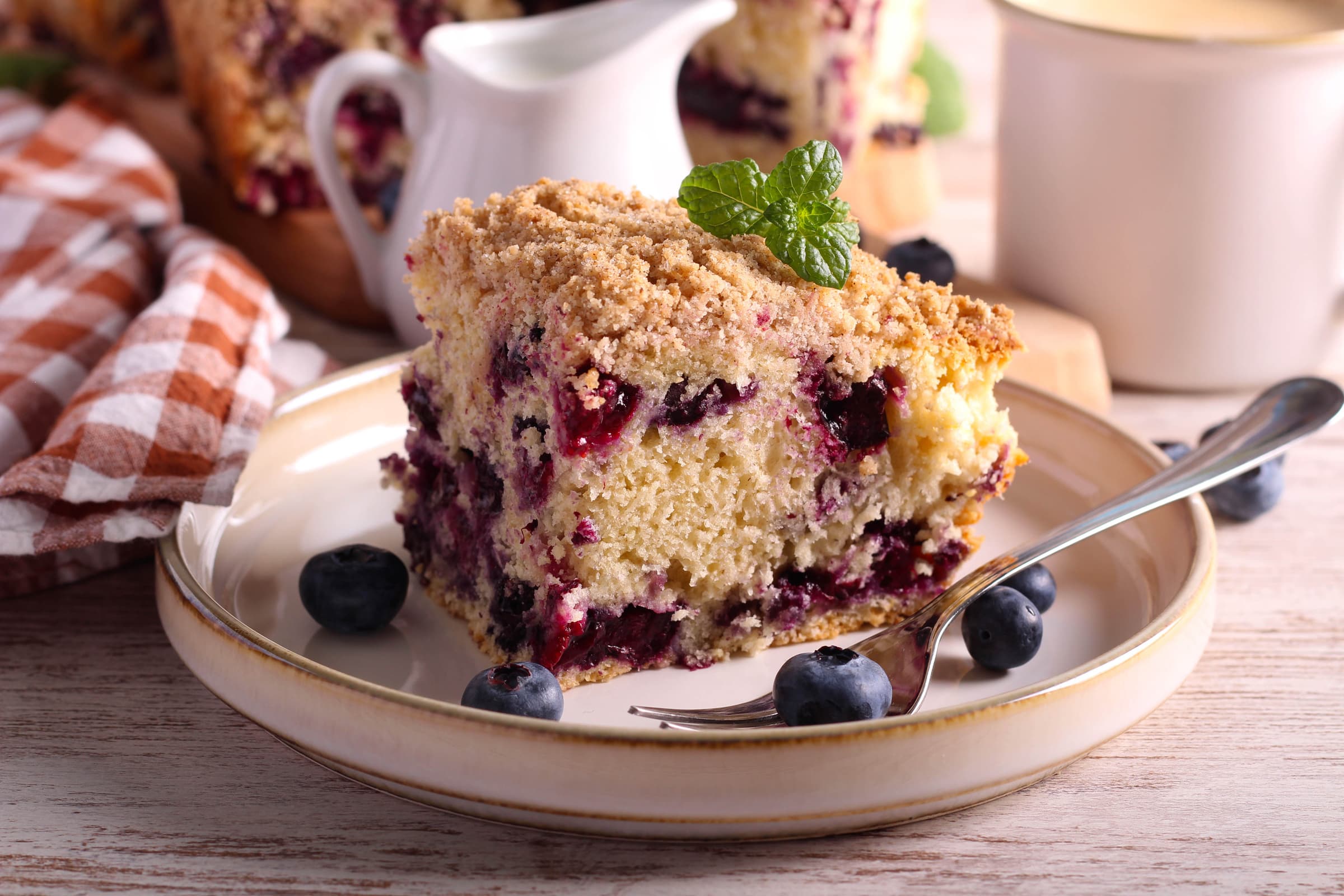 Morceau de gâteau aux bleuets avec garniture streusel dans une assiette.