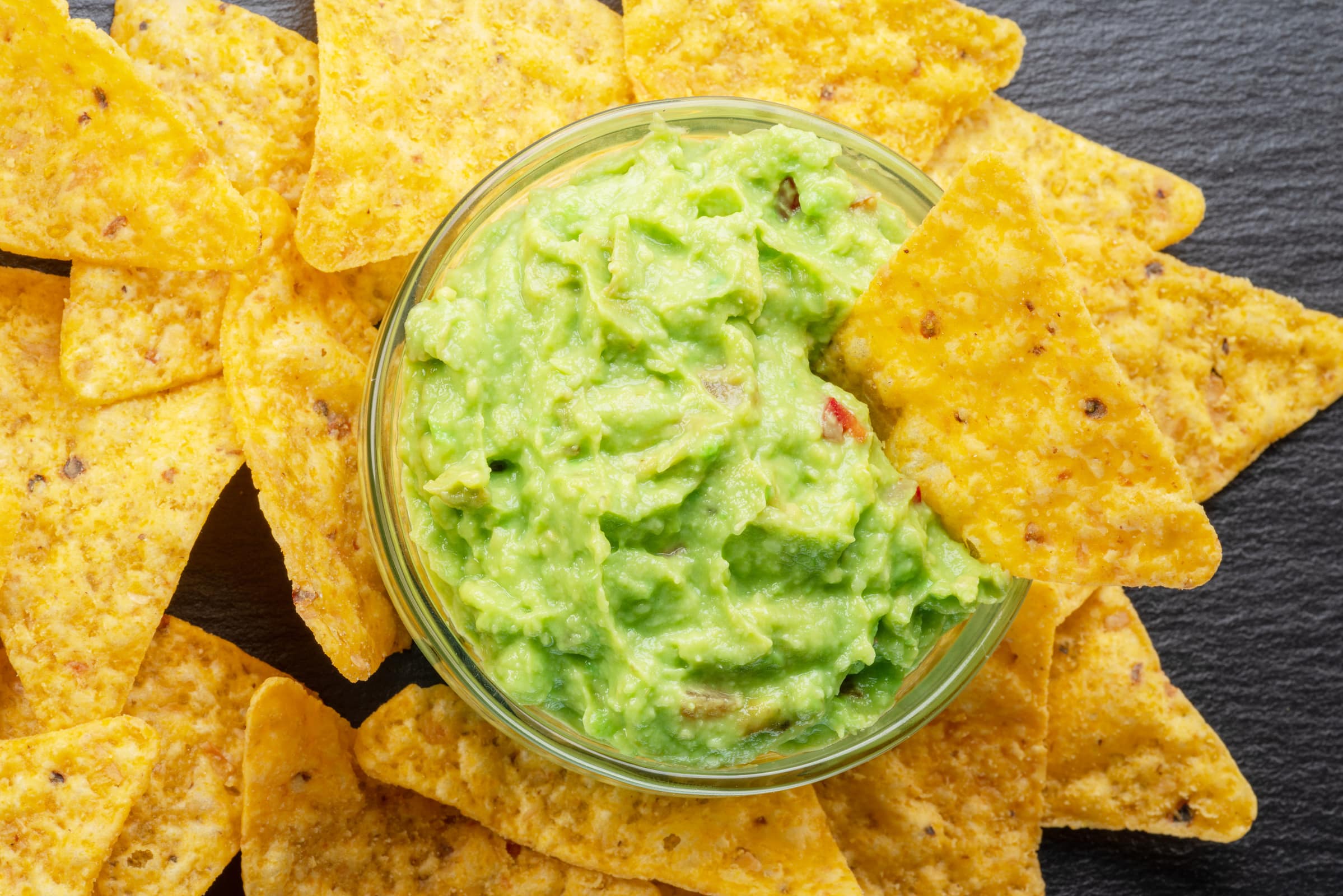 Guacamole maison servie dans un bol avec des chips de maïs style Nachos