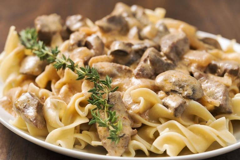 Boeuf Stroganoff cuit à l'autocuiseur Instant Pot avec nouilles aux œufs avec une branche de thym frais pour décorer.