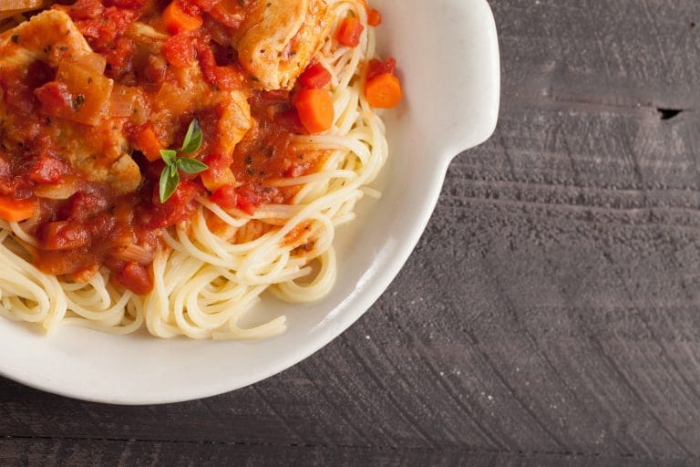 Poulet cacciatore cuit à l'autocuiseur Instant Pot servi sur des spaghettis dans un bol blanc