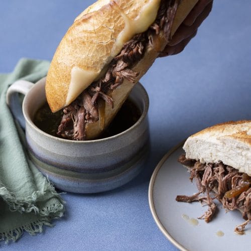 Sandwich au boeuf au Instant Pot que l'on trempe dans son jus de cuisson.