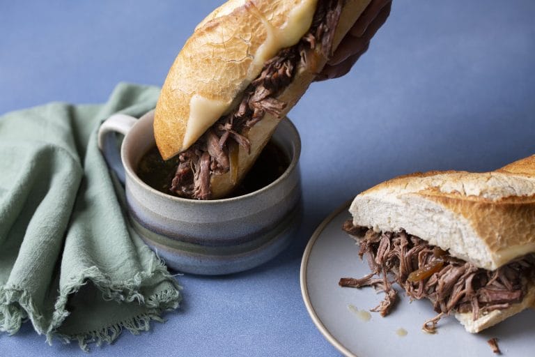 Sandwich au boeuf au Instant Pot que l'on trempe dans son jus de cuisson.