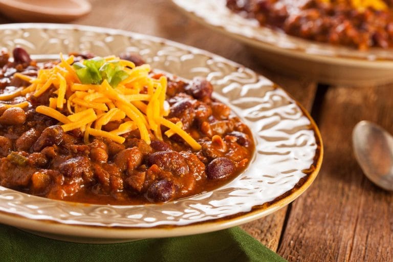 Chili cuit à la mijoteuse servi dans un bol avec du fromage sur le dessus