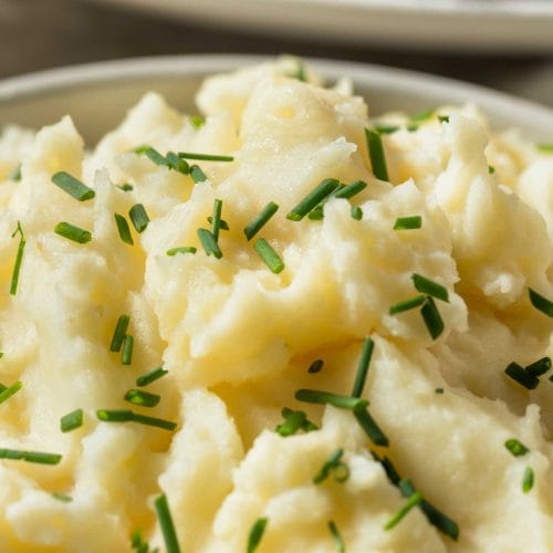 Purée de pommes de terre dans un bol blanc garni de ciboulette hachée