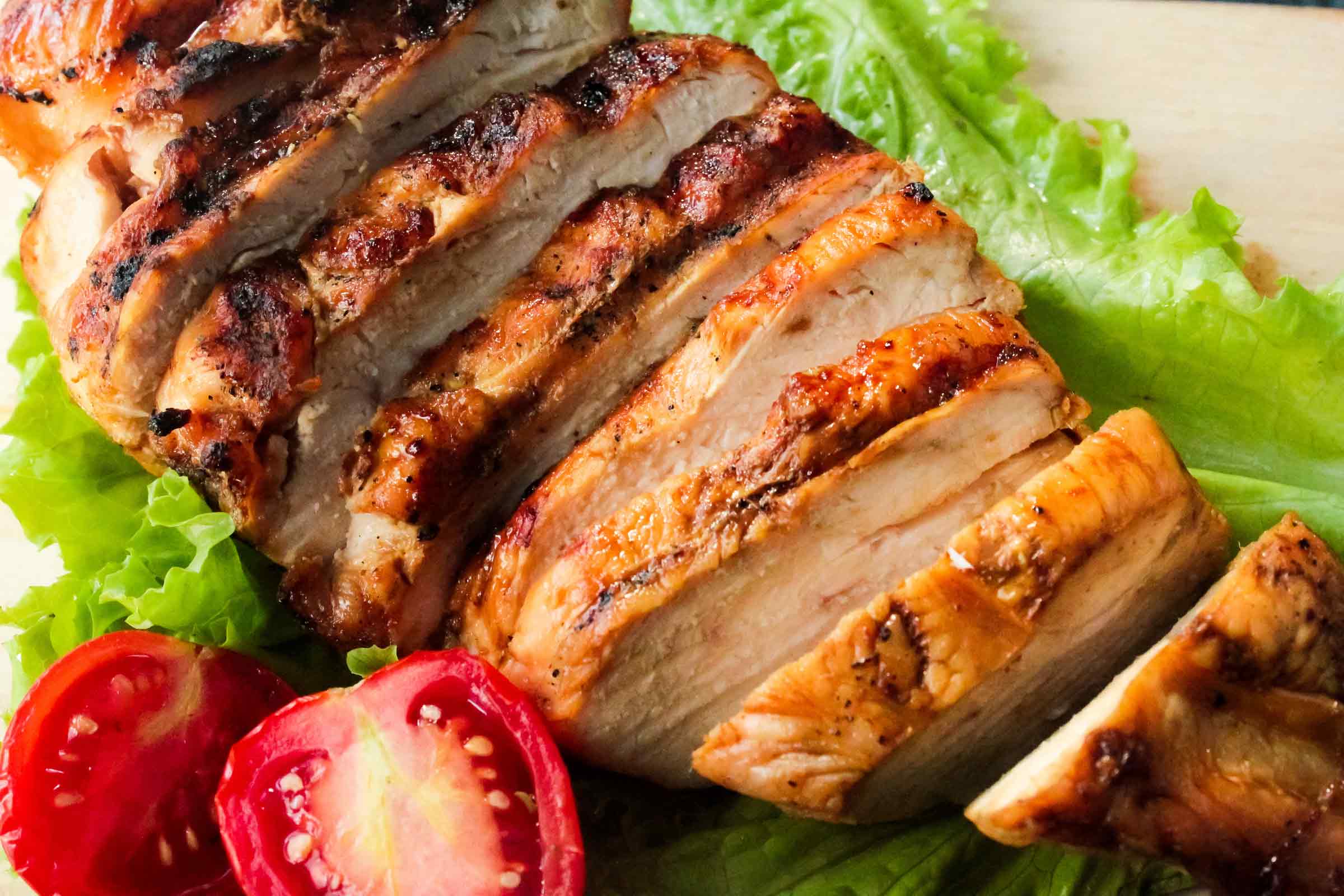 Poulet mariné avec une marinade pour le poulet en tranches et servi avec laitue et tomate